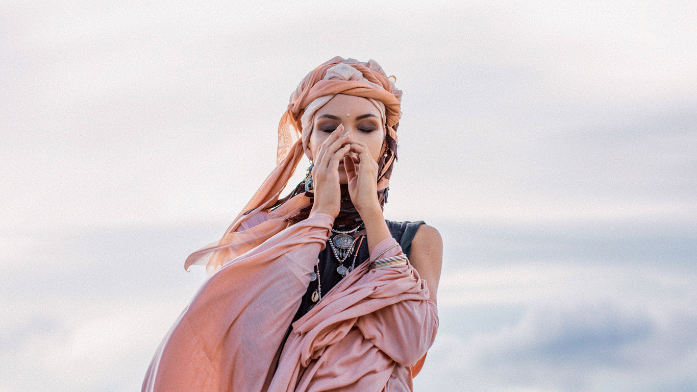 Eine Frau steht andächtig und schützt ihr Gesicht mit den Händen